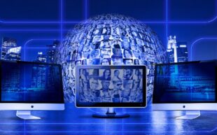 Computer screens in front of globe covered in faces with cityscape backdrop.